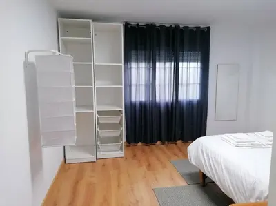 a bedroom with white shelves and a bed and a window at Lar de Yago - Apto Ribadeo in Ribadeo