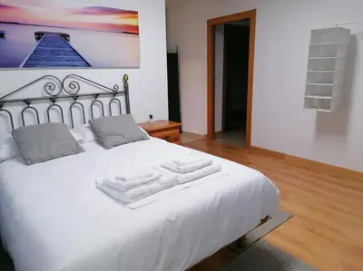 a white bed with two towels on top of it at Lar de Yago - Apto Ribadeo in Ribadeo