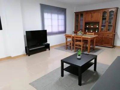 a living room with a table and a television at Lar de Yago - Apto Ribadeo in Ribadeo