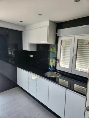 a kitchen with black and white cabinets and a sink at villa requian in Cacheiras