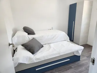 a bedroom with two beds with white sheets and gray pillows at villa requian in Cacheiras
