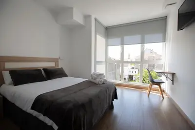 a bedroom with a bed and a large window at Pensión Roma in Castroverde