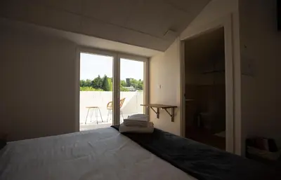 a bedroom with a large bed and a large window at Pensión Roma in Castroverde