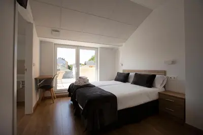 a bedroom with a large bed and a window at Pensión Roma in Castroverde
