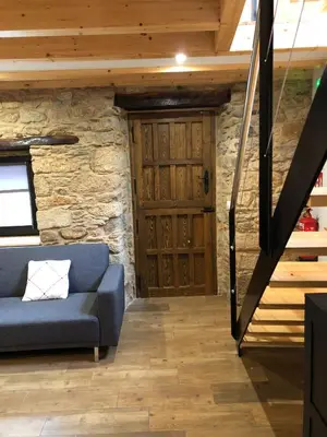 a living room with a blue couch and a wooden door at Apartamentos El Arroyo in Armal