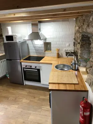 a kitchen with a sink and a stove at Apartamentos El Arroyo in Armal