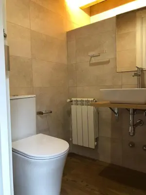 a bathroom with a toilet and a sink at Apartamentos El Arroyo in Armal