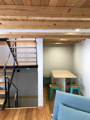 a loft bed in a room with a couch and a desk at Apartamentos El Arroyo in Armal