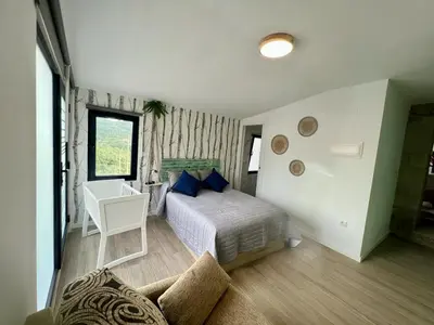 a bedroom with a bed with blue pillows and a desk at O Recuncho de Tibias in Pereiro de Aguiar
