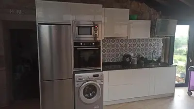 a kitchen with a refrigerator and a washing machine at O Recuncho de Tibias in Pereiro de Aguiar