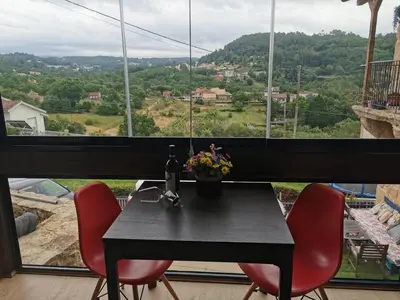 a black table with red chairs and a large window at O Recuncho de Tibias in Pereiro de Aguiar