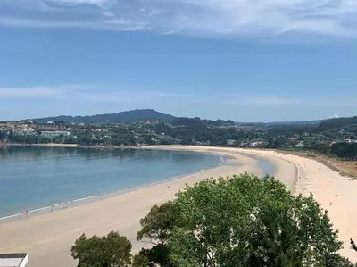 a view of a beach with people in the water at Piso primera línea playa Miño/La Coruña in Miño