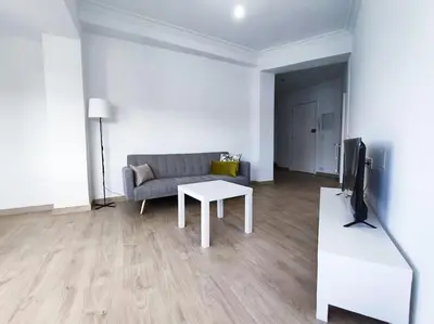 a living room with a couch and a tv and a table at Mariña Home in Ourense