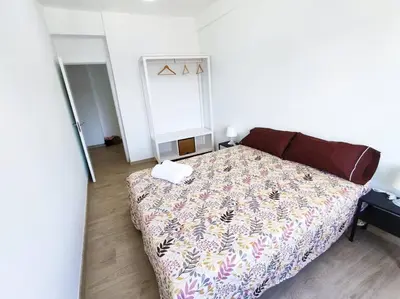 a bedroom with a bed with a flowered blanket at Mariña Home in Ourense