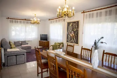 a dining room and living room with a dining table at Casa Rural Fidalgo in Chantada