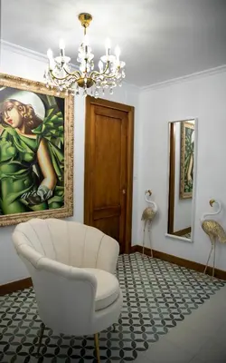 a living room with a white chair and a painting at Casa Rural Fidalgo in Chantada