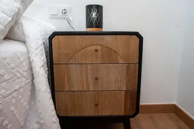 a dresser with a lamp on top of it next to a bed at Casa Rural Fidalgo in Chantada