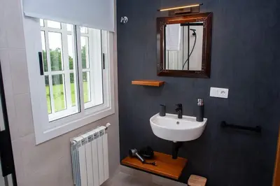 a bathroom with a sink and a mirror and a window at Casa Rural Fidalgo in Chantada