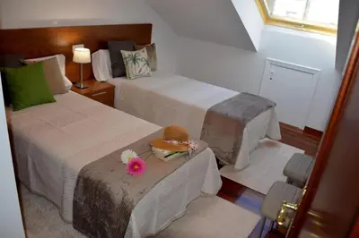 a hotel room with two beds and a hat on a table at HHC - Duplex Concheiros, 4 bedrooms, 3 bathroom, a 700m de la Catedral in Santiago de Compostela