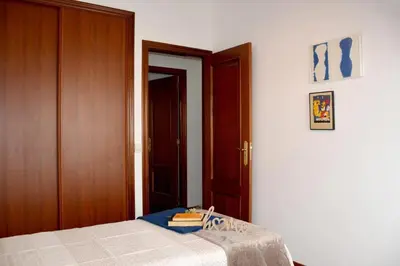 a bedroom with a bed and a wooden door at HHC - Duplex Concheiros, 4 bedrooms, 3 bathroom, a 700m de la Catedral in Santiago de Compostela