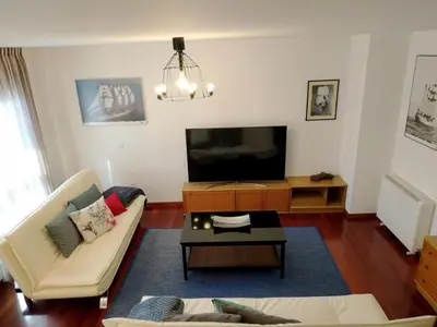 a living room with a couch and a flat screen tv at HHC - Duplex Concheiros, 4 bedrooms, 3 bathroom, a 700m de la Catedral in Santiago de Compostela