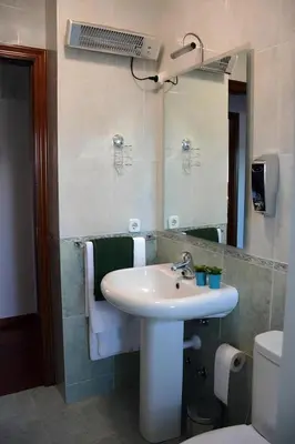 a bathroom with a sink and a mirror and a toilet at HHC - Duplex Concheiros, 4 bedrooms, 3 bathroom, a 700m de la Catedral in Santiago de Compostela