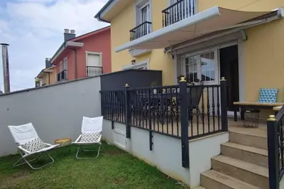 a patio with two chairs and a table on a balcony at Preciosa casa en Ribadeo in Ribadeo