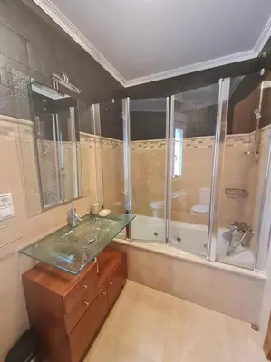 a bathroom with a glass shower and a sink at Preciosa casa en Ribadeo in Ribadeo