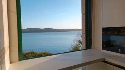 a room with a large window with a view of the water at SALSEIRAZO - PLAYA A RIBEIRA MIÑO in Miño