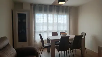 a dining room with a table and chairs and a window at SALSEIRAZO - PLAYA A RIBEIRA MIÑO in Miño