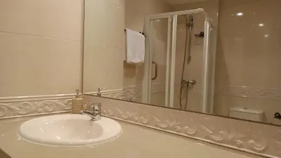 a white bathroom with a sink and a shower at SALSEIRAZO - PLAYA A RIBEIRA MIÑO in Miño