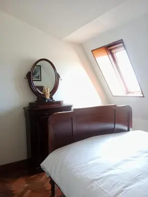 a bedroom with a bed and a mirror on a dresser at Sobre la Ría 2 in Viveiro