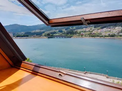 a view of a large body of water from a window at Sobre la Ría 2 in Viveiro