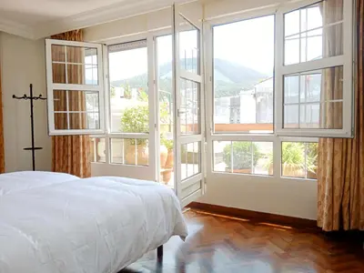 a bedroom with a bed and large windows at Sobre la Ría 2 in Viveiro
