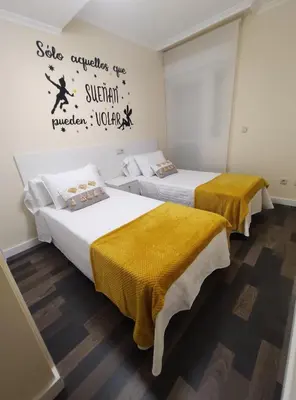 a room with two beds with yellow sheets at Apartamento Tamarisco in Foz