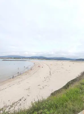 a beach with people swimming in the water at Apartamento Tamarisco in Foz