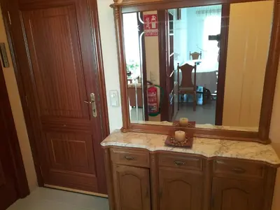 a bathroom with a large mirror and a wooden cabinet at O NOSO FOGAR in Melide