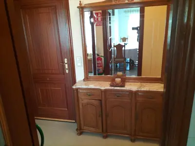 a bathroom with a large mirror and a wooden cabinet at O NOSO FOGAR in Melide