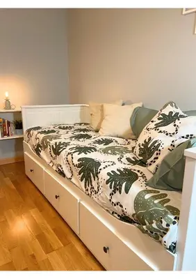 a white bed with a green and white comforter at Gran vía in Ribadeo