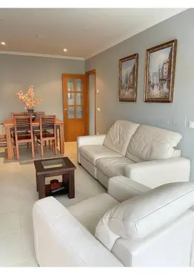 a living room with a white couch and a table at Gran vía in Ribadeo