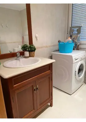 a bathroom with a sink and a washing machine at Gran vía in Ribadeo