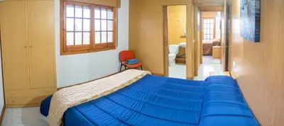 a bedroom with a blue bed and a bathroom at Casa Manolo Camiño Do Santiaguiño in Vedra