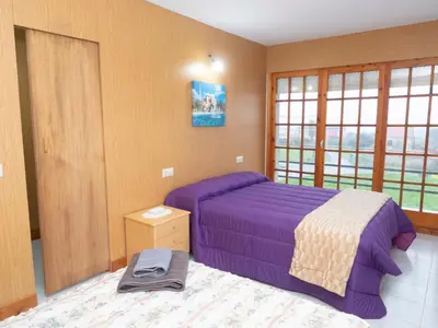 a bedroom with a purple bed and a window at Casa Manolo Camiño Do Santiaguiño in Vedra