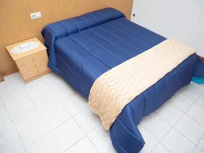 a blue bed in a room with a table at Casa Manolo Camiño Do Santiaguiño in Vedra