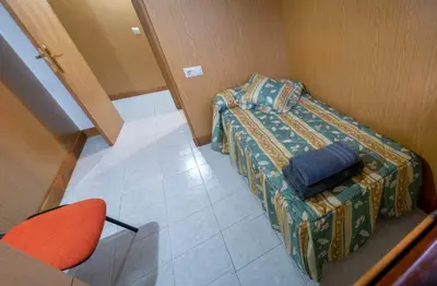 a small room with a bed and a chair at Casa Manolo Camiño Do Santiaguiño in Vedra