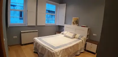 a small bedroom with a bed and two windows at Entre Las Catedrales Campo y Mar 1 y 2 in Lourenzá