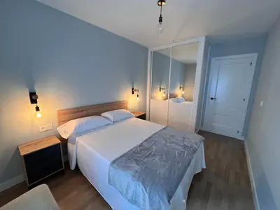 a bedroom with a large bed and a mirror at Vagalume in Cervo