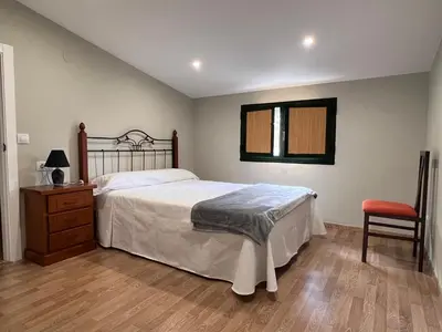 a bedroom with a large bed and a chair at Vagalume in Cervo