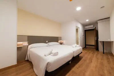 a bedroom with a large white bed with a bow on it at ESTRELA DO CAMIÑO in Palas de Rei