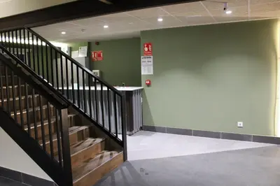a hallway with a staircase and a green wall at ESTRELA DO CAMIÑO in Palas de Rei